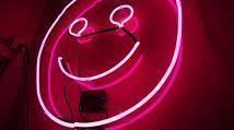 Pink neon sign in the shape of a smiley face